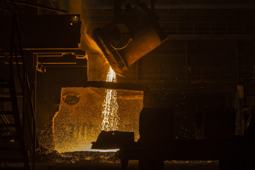 Hehkuvan kuumaa sulaa metallia kaadetaan Ovakon tehtaalla.