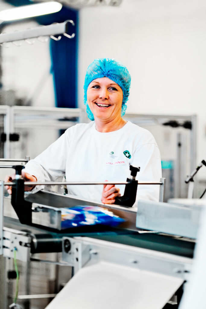 Prosessinhoitaja hymyilee Lantmännenin tuotantolinjalla.)