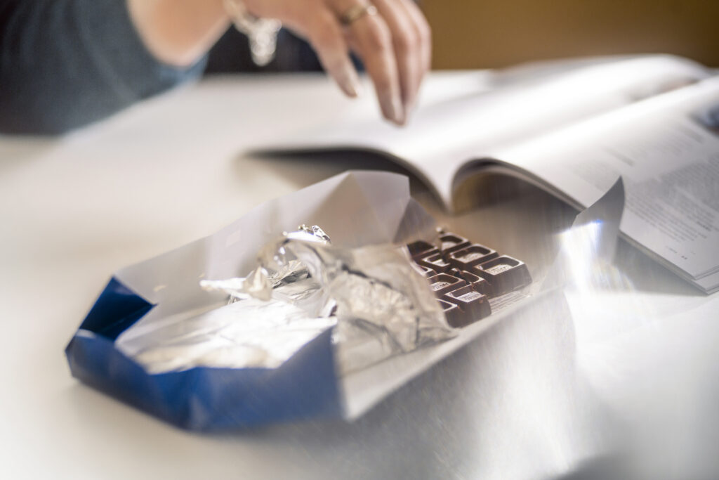 Pöydällä suklaalevy, jonka avattu kääre levällään.